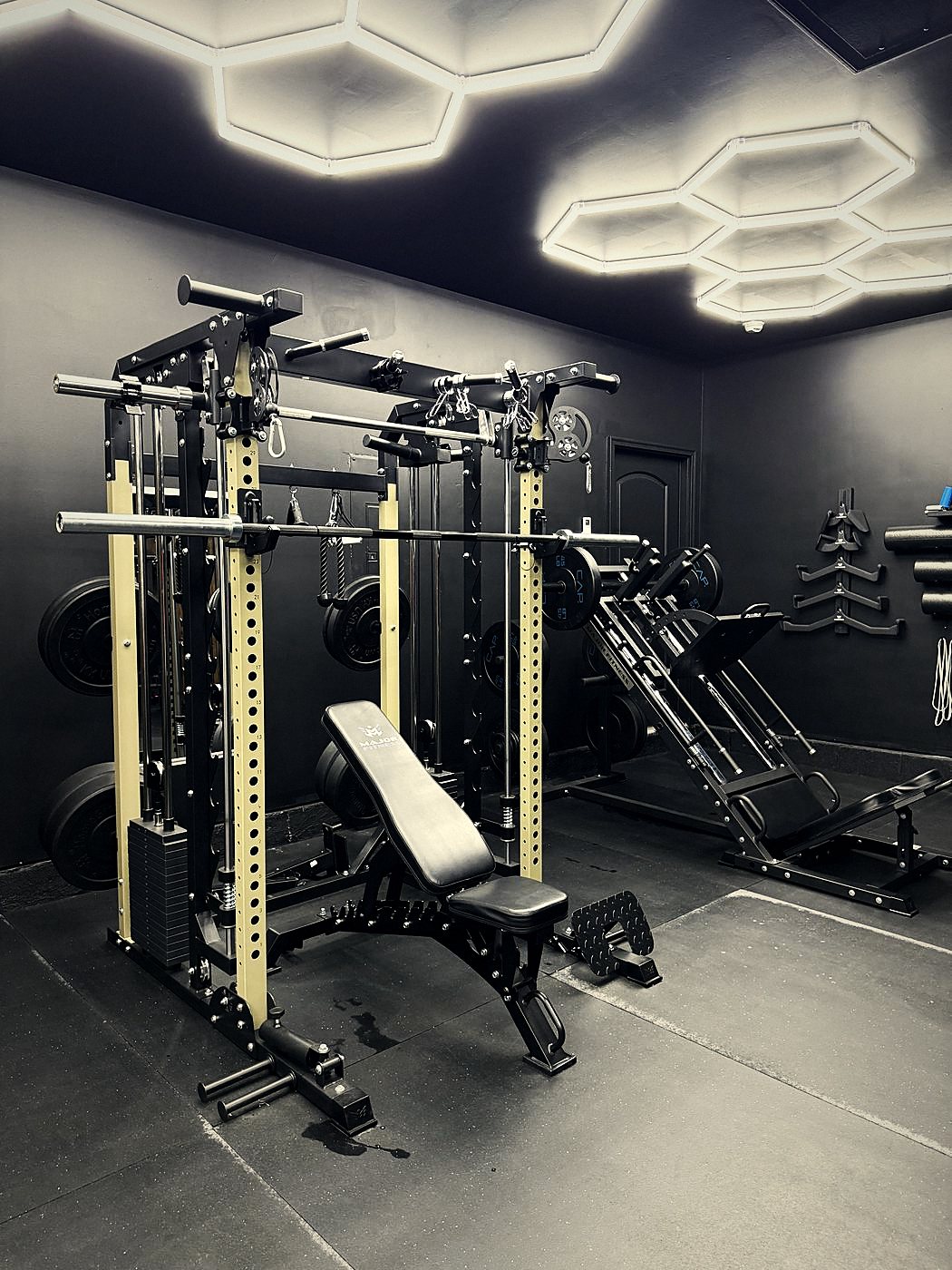 Strength training rack with cables, free weights, and adjustable bench